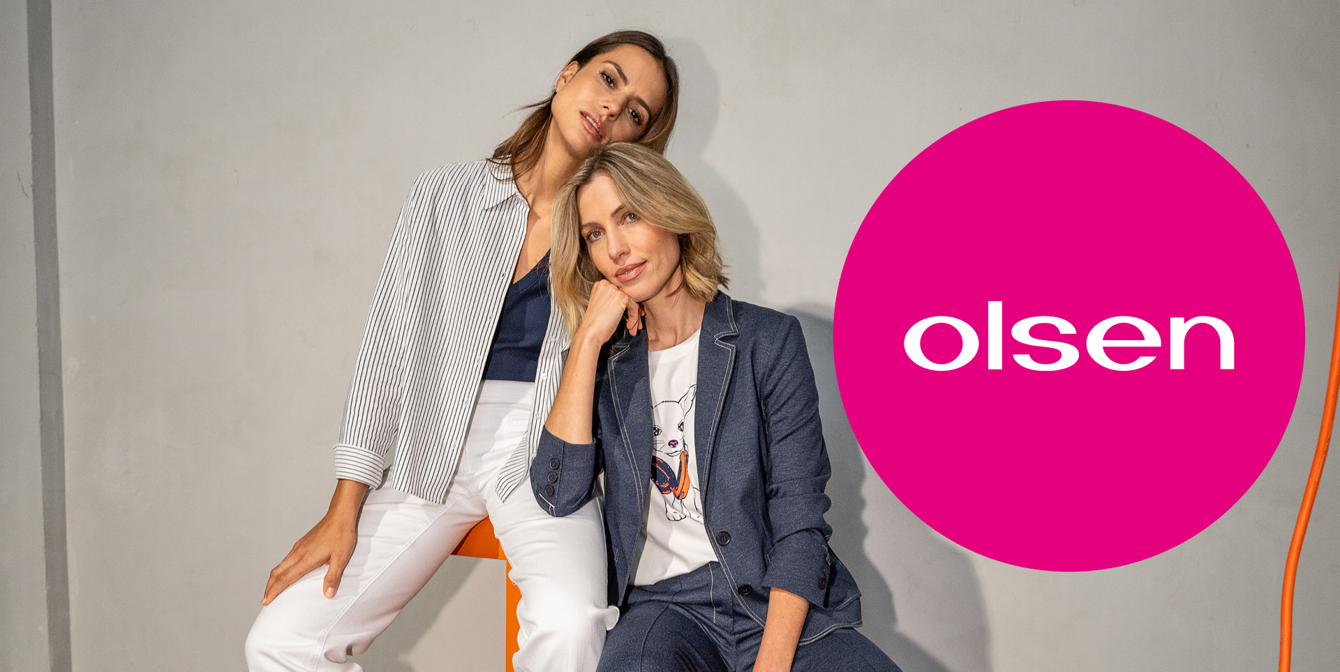 Zwei Frauen sitzen auf einem Stuhl mit der Aufschrift „olsen“. Zwei Frauen sitzen auf einem Stuhl mit der Aufschrift "olsen".