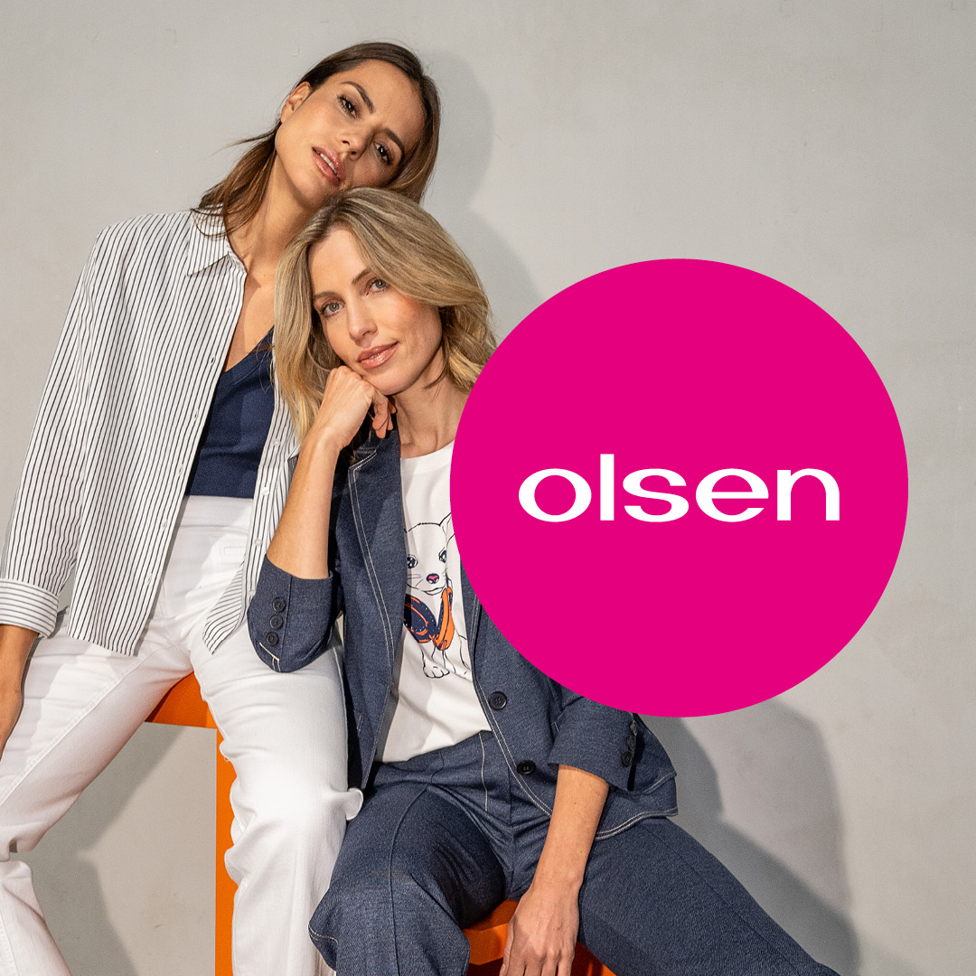 Zwei Frauen sitzen auf einem Stuhl mit der Aufschrift „olsen“. Zwei Frauen sitzen auf einem Stuhl mit der Aufschrift "olsen".