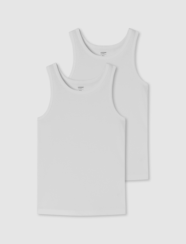 Zwei weiße Tanktops liegen auf einem weißen Hintergrund. Zwei weiße Tanktops liegen auf einem weißen Hintergrund.